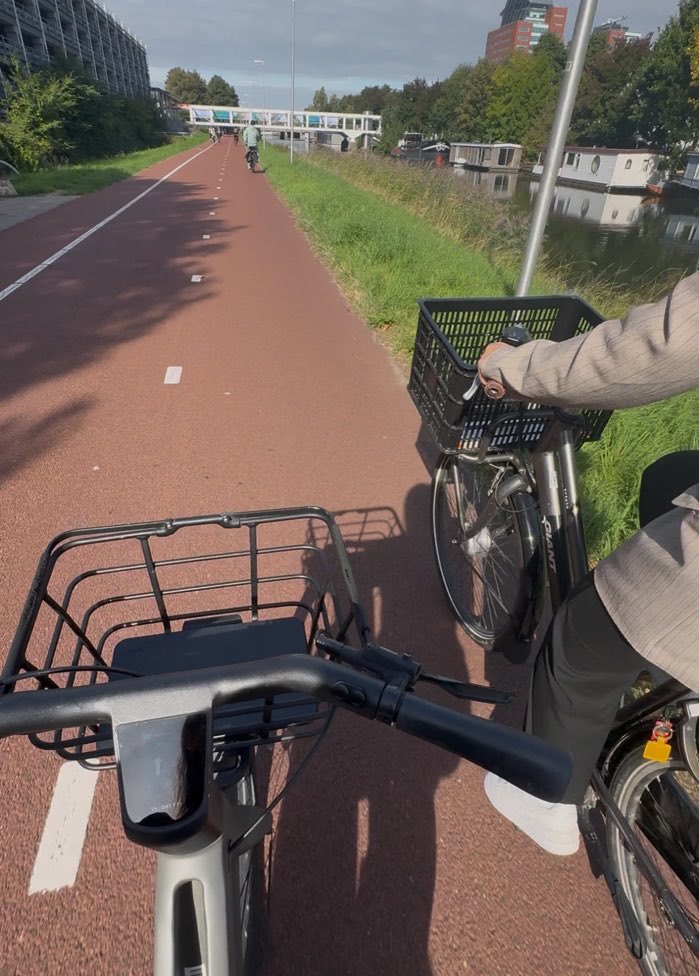 Fietsend langs het water in Utrecht, onderweg tussen de huizen
